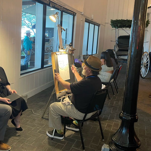 traditional caricature artist sketching a couples' portrait at a wedding